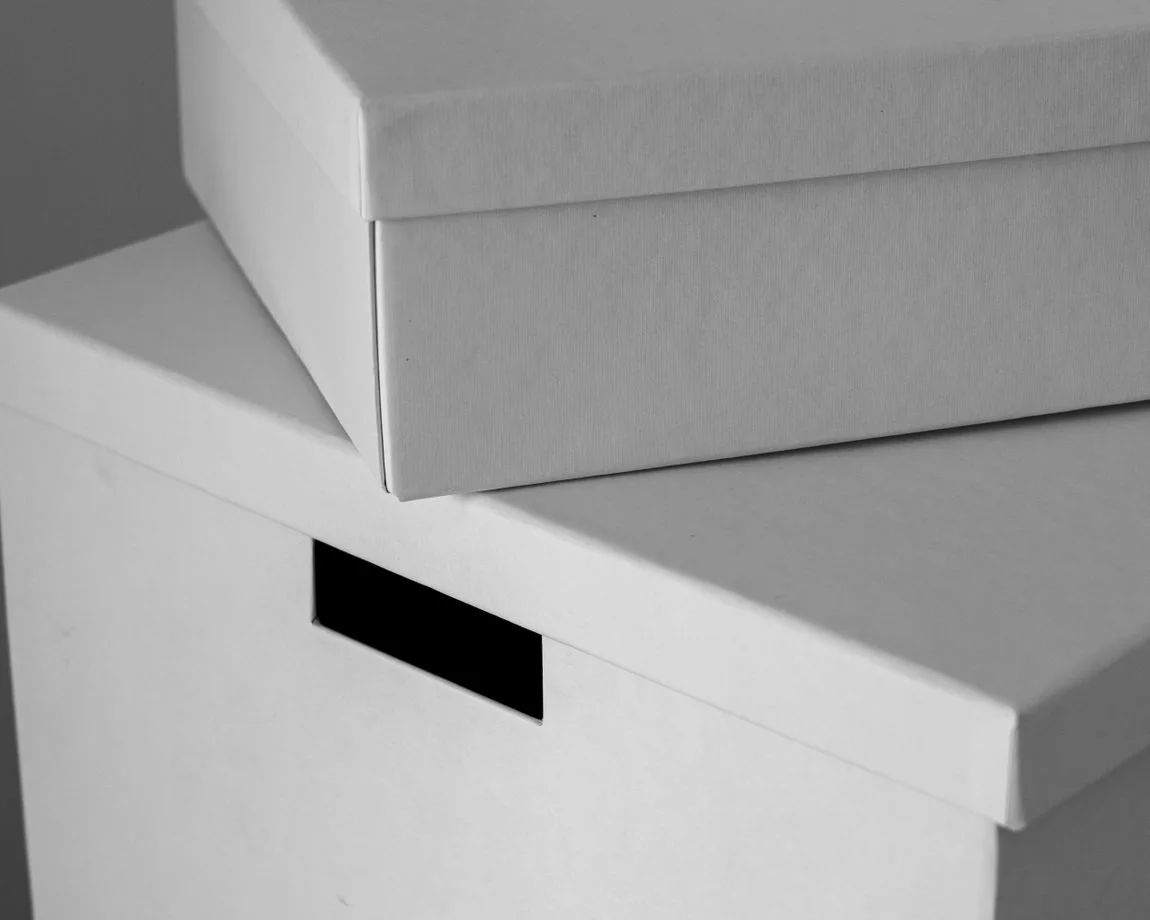 Close-up of minimalist white cardboard boxes stacked with ample copy space. Ideal for design or storage themes.