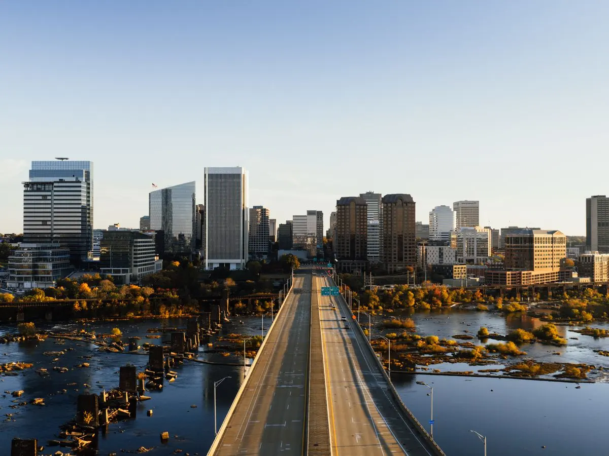 Stunning aerial shot of Richmond, Virginia skyline and bridge over water in daylight.