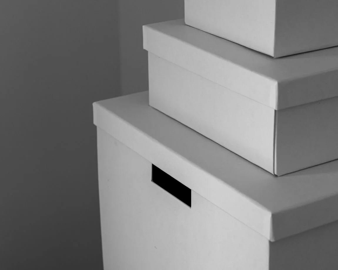 Minimalist close-up of white storage boxes stacked indoors. Perfect for organization themes.